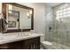 Bathroom featuring white marble tile and a shower with glass surround, accompanied by a dark wood vanity at 6929 E Montreal Pl, Scottsdale, AZ 85254