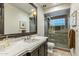 Bathroom showcasing a modern vanity with a quartz countertop and a shower featuring glass block accents at 6929 E Montreal Pl, Scottsdale, AZ 85254