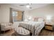 Cozy bedroom with natural light, tufted ottoman, a decorative chair and wood laminate floors at 7412 S Elm St, Tempe, AZ 85283