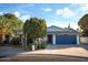 Single story home featuring a large driveway and a two car garage with desert landscaping at 7412 S Elm St, Tempe, AZ 85283