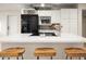 Modern kitchen featuring white cabinets, stainless steel appliances, and a large island with wooden stools at 7412 S Elm St, Tempe, AZ 85283
