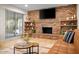 Inviting living room with a brick fireplace and built-in shelving adjacent to a sliding glass door at 7412 S Elm St, Tempe, AZ 85283