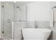 Spa-like bathroom with a soaking tub and frameless glass shower with marble-look tile at 7694 E Minnezona Ave, Scottsdale, AZ 85251