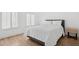 Bright, minimalist bedroom with wood-look floors and plantation shutters at 7694 E Minnezona Ave, Scottsdale, AZ 85251