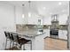 Modern kitchen with stainless steel appliances, granite countertops, and a breakfast bar at 7694 E Minnezona Ave, Scottsdale, AZ 85251