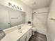 Neutral bathroom features a single sink vanity with a mirror and a tiled shower-tub combo at 8512 W Tuckey Ln, Glendale, AZ 85305