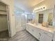 Bright bathroom features a single sink vanity, a shower-tub combo, and a walk-in closet at 8512 W Tuckey Ln, Glendale, AZ 85305
