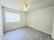 Bright, empty bedroom with a window, wood-look tile flooring, ceiling fan and neutral walls at 8512 W Tuckey Ln, Glendale, AZ 85305