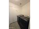 Modern laundry room with dark-colored, front-loading washing machine and dryer at 8512 W Tuckey Ln, Glendale, AZ 85305