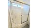 The shower-tub has a white tiled surround, sliding glass doors, and a window for natural light at 8512 W Tuckey Ln, Glendale, AZ 85305