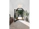 Elegant foyer with an arched doorway, stone floors, statement chandelier, and an inviting view of the landscaped front yard at 8601 N 59Th Pl, Paradise Valley, AZ 85253