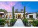 Stunning stone facade with arched entryway, manicured lawn, and lush landscaping creates a welcoming curb appeal at 8601 N 59Th Pl, Paradise Valley, AZ 85253
