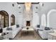 Elegant living room featuring a stone fireplace, chandeliers, and white sofas in a bright, open space at 8601 N 59Th Pl, Paradise Valley, AZ 85253