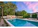 Backyard pool with stone fireplace, lush greenery, and a tranquil spa at 8601 N 59Th Pl, Paradise Valley, AZ 85253