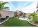 This home boasts a backyard oasis with a sparkling pool, lush landscaping, and comfortable lounge area at 9908 E Medina Ave, Mesa, AZ 85209