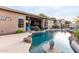 Backyard features a beautiful pool with rock features and an outdoor seating area with a firepit at 9908 E Medina Ave, Mesa, AZ 85209