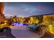 A captivating backyard pool with ambient lighting, waterfall features, and relaxing lounge areas for serene outdoor enjoyment at 9908 E Medina Ave, Mesa, AZ 85209