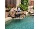 Relax by the tranquil pool with a waterfall and peaceful Buddha statue, surrounded by lush landscaping and serene garden at 9908 E Medina Ave, Mesa, AZ 85209