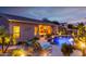 A well lit backyard pool with lounge chairs is adjacent to the home, creating an inviting outdoor living space at 9908 E Medina Ave, Mesa, AZ 85209