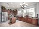 Well-lit kitchen with custom cabinets, stainless steel appliances, a center island, and tiled floors at 9908 E Medina Ave, Mesa, AZ 85209