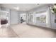 Open-concept living room with light walls and carpeting plus large windows offering views of the outdoor pool at 9908 E Medina Ave, Mesa, AZ 85209