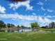 Picturesque view of a pond on a golf course, complete with a fountain and clear blue sky backdrop at 9908 E Medina Ave, Mesa, AZ 85209