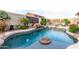 An inviting backyard pool features rock features, lush landscaping, and a soothing waterfall at 9908 E Medina Ave, Mesa, AZ 85209