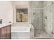 Well lit bathroom with a glass enclosed shower and soaking tub with tile surround at 10713 N 124Th Pl, Scottsdale, AZ 85259
