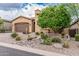 A cozy home featuring desert landscaping with rocks, a cactus, and a mature shade tree at 10713 N 124Th Pl, Scottsdale, AZ 85259