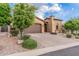 Lovely home showcases mature trees, desert landscaping, paver driveway, and attached two-car garage at 10713 N 124Th Pl, Scottsdale, AZ 85259
