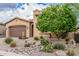 Tan home with desert landscaping, rocks, a cactus, and a green tree at 10713 N 124Th Pl, Scottsdale, AZ 85259