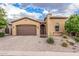 Well-maintained home features a desert landscape, a paver driveway, and a charming arched front door at 10713 N 124Th Pl, Scottsdale, AZ 85259