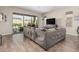 Bright and airy living room with a large sofa, wood floors, and sliding glass doors to the outdoor patio at 10713 N 124Th Pl, Scottsdale, AZ 85259