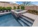 Close-up view of pool with spa and steps, surrounded by lush greenery and decorative tile accents at 10713 N 124Th Pl, Scottsdale, AZ 85259