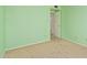 Bright green bedroom featuring neutral carpet, door, and electrical outlets at 1114 W Meseto Ave, Mesa, AZ 85210