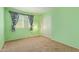 Bright green bedroom featuring window with floral curtains and closet at 1114 W Meseto Ave, Mesa, AZ 85210