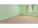 Bright green bedroom featuring neutral carpet and window with floral curtains at 1114 W Meseto Ave, Mesa, AZ 85210