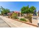 Inviting front yard featuring brick accents, desert landscaping, mature trees, and a gated courtyard entry at 1114 W Meseto Ave, Mesa, AZ 85210