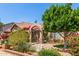 Inviting front yard featuring brick accents, mature trees, desert landscaping, and a gated courtyard entry at 1114 W Meseto Ave, Mesa, AZ 85210