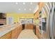 Spacious kitchen featuring granite countertops, stainless steel appliances, and natural wood cabinetry with plenty of counterspace at 1114 W Meseto Ave, Mesa, AZ 85210