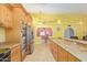 Open kitchen with a large island, stainless steel appliances, and natural wood cabinetry, making it perfect for cooking at 1114 W Meseto Ave, Mesa, AZ 85210
