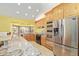 Modern kitchen with stainless steel appliances, granite countertops, and natural wood cabinetry, creating a functional space at 1114 W Meseto Ave, Mesa, AZ 85210