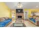 Cozy living room with a brick fireplace, tile flooring, and bright windows, perfect for relaxing or entertaining at 1114 W Meseto Ave, Mesa, AZ 85210