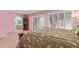 Pink main bedroom featuring plantation shutters, ensuite bathroom, and floral comforter at 1114 W Meseto Ave, Mesa, AZ 85210
