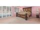 Comfortable main bedroom with a decorative headboard, carpet flooring, and large windows with views of the backyard pool at 1114 W Meseto Ave, Mesa, AZ 85210