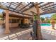 A covered patio area with a dining table and chairs overlooking the pool and backyard at 1114 W Meseto Ave, Mesa, AZ 85210