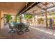 Covered patio area featuring brick pavers, outdoor furniture, and decor at 1114 W Meseto Ave, Mesa, AZ 85210