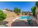 The backyard featuring a pool with a diving board, patio, and mature landscaping at 1114 W Meseto Ave, Mesa, AZ 85210