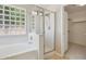 Beautiful bathroom featuring a shower, bathtub, and decorative glass block window at 11351 N 153Rd Dr, Surprise, AZ 85379