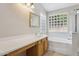 Bright bathroom featuring a large mirror, vanity, and decorative glass block window at 11351 N 153Rd Dr, Surprise, AZ 85379